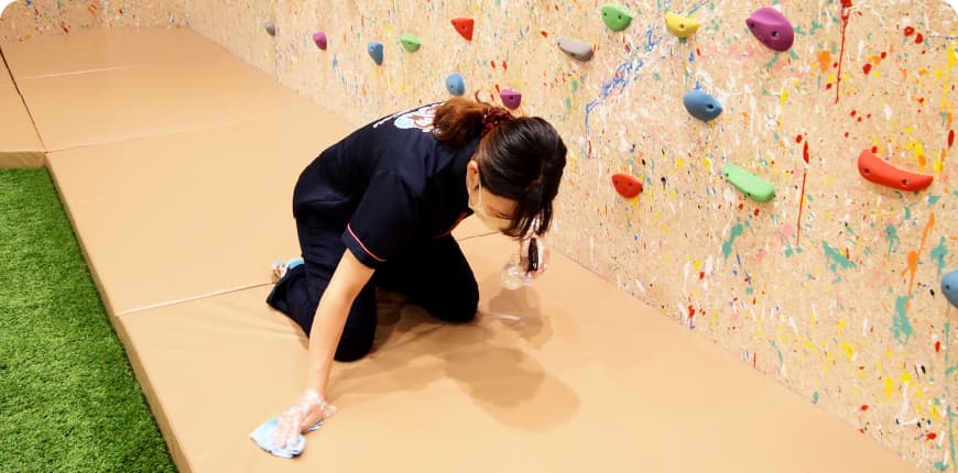 床を消毒しているスタッフの画像